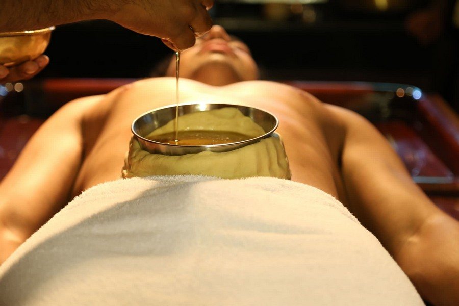 Warm oil being poured into a dough well placed over a client's heart center