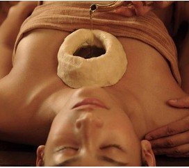 Dough ring holding warm oil placed over a client's throat area