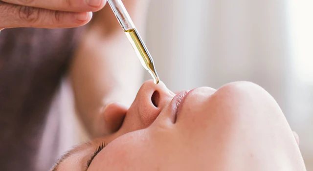 Warm herbal Nasya oil being applied to the nasal passages
